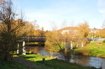 Obraz premium Colorful bridge view, Picturesque scene of vibrant river with treelined banks and historic stone bridge