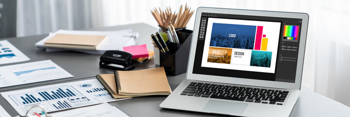 Data analysis dashboard display on laptop screen on office table with financial papers by Fintech...