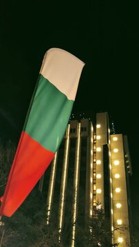 Sur fond de b&acirc;timent d&eacute;cor&eacute;, un drapeau tricolore flotte dans la brise l&eacute;g&egrave;re du soir.