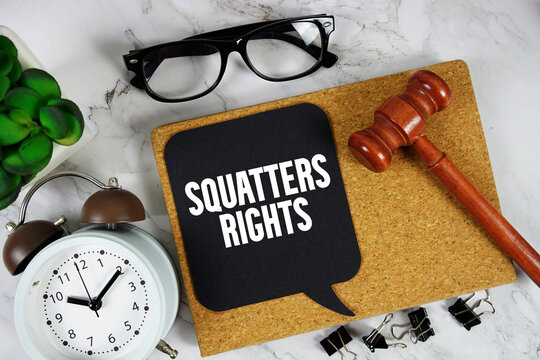 Squatters Rights text on speech bubble with alarm clock and wooden gavel on marble background