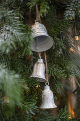 Silver bell hanging on a pine