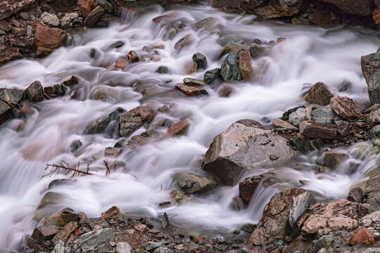 View of rushing water cascades over rugged rocks, creating a dynamic interplay of motion and texture, a serene yet powerful scene, Kalam, Khyber Pakhtunkhwa, Pakistan.