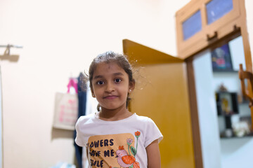 Girl standing in a room with open door and bright light
