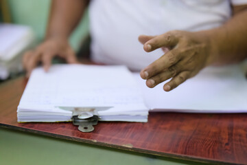 Hands gesturing over stacked papers on a table