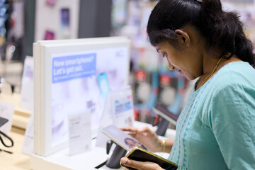 Woman checking smartphone options inside a store