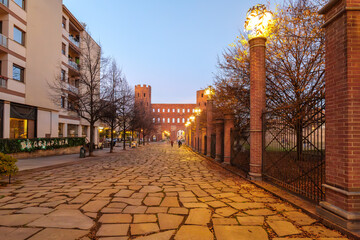 Turin, Italy. Porta Palatina seen from Piazza Giulio Cesare at dusk, ancient Roman gate of Augusta...