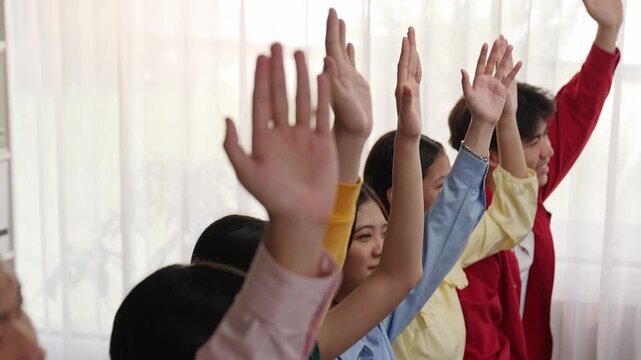 Group of interviewee candidate in colorful casual wearing line up for vacancy interview sitting on the chair. Intern raise hand. Job opportunity recruitment for HR agency and vacancy concept. Synergic