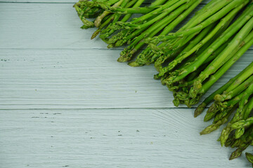 Bunch of fresh green asparagus stems on wooden background