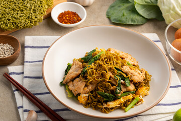 Stir fried green instant Japanese style vegetable noodles with Dark Soy Sauce in white plate.Asian food with low calories and healthy food.