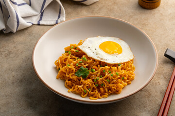 instant noodles and egg.dry noodles with shrimp tom yum soup flavour and fried egg in a plate.