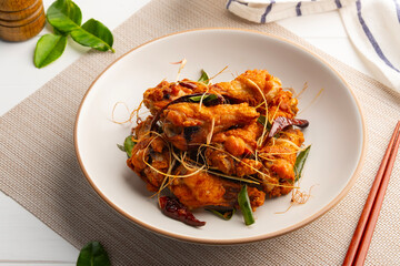 Fried chicken wingstick with fish sauce.Chicken drumettes with crispy lemongrass ,chilli and Kaffir lime leaves in white plate.
