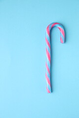 Merry Christmas card. Candy cane on a blue background.