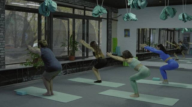 Group practicing standing backbend and twists in class.