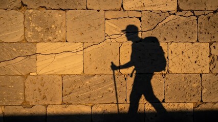 Shadow Hiker on Stone Wall