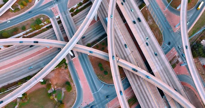 Cars run by the multi-level interchange. Transportation and logistics concept. Top view.