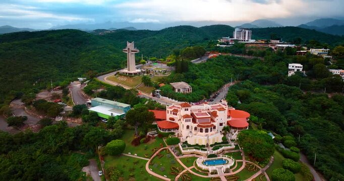 Majestic scenery of Castillo Serrall&eacute;s in Ponce, Puerto Rico surrounded by lush greenery. The Watchman Cross at backdrop. Aerial view.