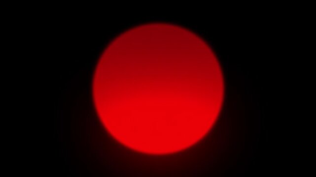 Abstract glowing red neon circular light sphere on a solid black background