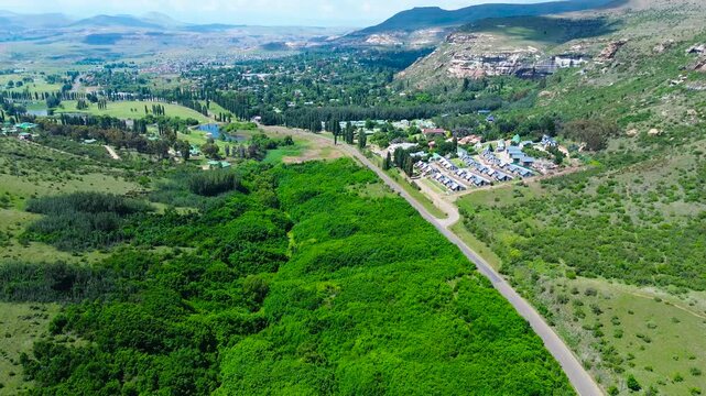 Camera panning up along the road leading to Clarens South Africa with the Maluti Mountains on both sides 4K Aerial Video.