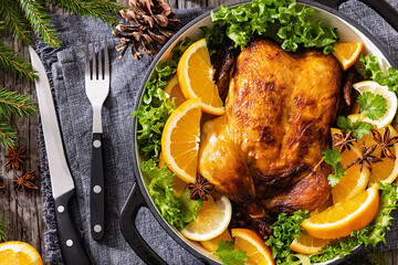 Whole roasted chicken in baking dish with citrus