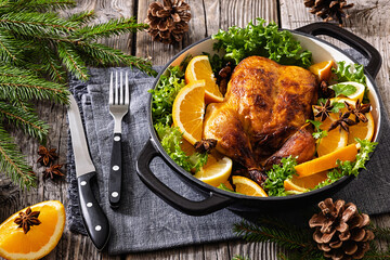 Whole roasted chicken in baking dish with citrus