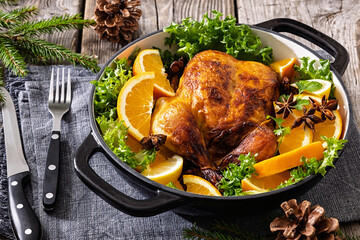 Whole roasted chicken in baking dish with citrus