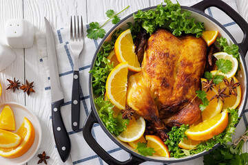 Whole roasted chicken in baking dish with citrus