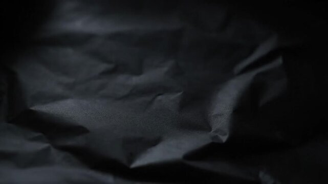 Abstract dark crumpled fabric on black background