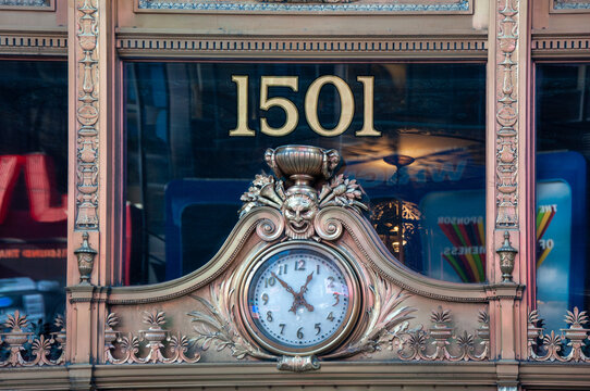 View of an ornate clock beneath the number 1501 adorns a building facade, detailed with intricate carvings and gilded accents, New York, New York, United States.