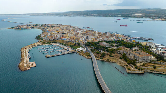 Aerial view of the town of Augusta, in province of Syracuse, Sicily, Italy. The historic centre is built on an island overlooking the Mediterranean Sea. In foreground are the port and Swabian castle.