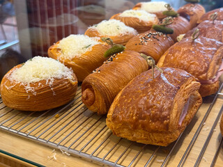 Savory croissants and pastries in bakery display. Texture, flavor, and artisanal baking in modern cafe presentation.