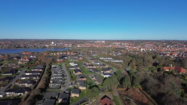 Aerial video of  Haderslev city in Denmark and lake with suburban homes and historic urban skyline