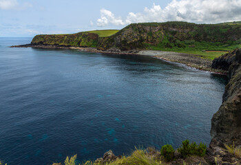 Dramatic volcanic cliffs at Alagoa Viewpoint overlooking the deep blue Atlantic Ocean on Terceira Island, Azores, Portugal, showcasing rugged lava coast scenery and natural beauty
