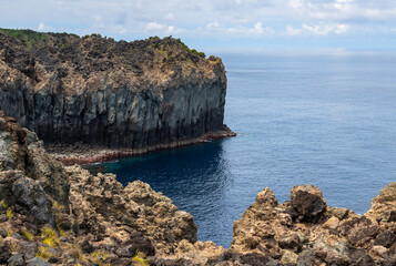 Dramatic volcanic cliffs at Alagoa Viewpoint overlooking the deep blue Atlantic Ocean on Terceira Island, Azores, Portugal, showcasing rugged lava coast scenery and natural beauty