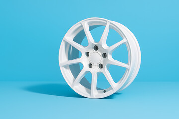 Fototapeta premium Modern white alloy car wheel rim isolated against pastel blue background in clean simple automotive design concept