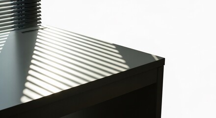 Fototapeta premium Sunlight stripes cast shadows across a dark desk surface
