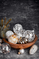 Glass toys, balls and decorations for Christmas tree in old wooden bowl in rustic style. Greeting card with copyspace. top view on grunge background