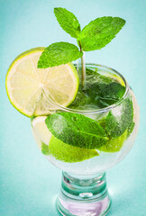 Glass of fresh mojito cocktail over light blue