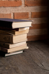 Old thick books on a dark windowsill near a large window