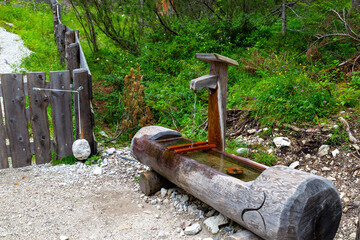 Man-made wellspring in mountain meadow close-up