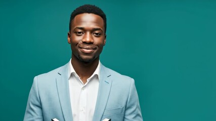 African man in light blue suit holding book and smiling for studio profile picture. Content for professional or academic advertisement background.
