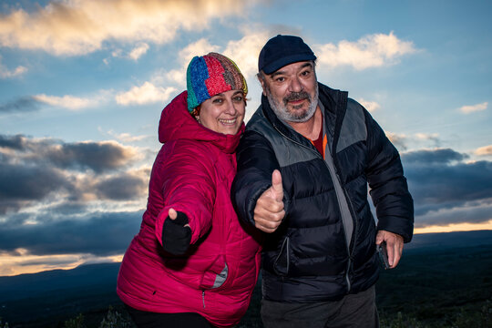  Una pareja de 61 a&ntilde;os con los pulgares levantados saludando en un atardecer en las monta&ntilde;as de Valencia