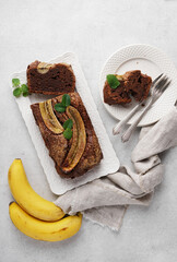 Homemade banana bread with dark chocolate close-up on table. Vertical top view