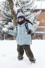 happy schoolboy kid wearing warm clothes in snow