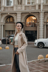 A young girl with a cup of takeaway coffee. Lunch break from school or work on the street.