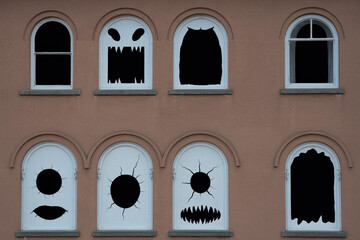 An ancient stone facade of a vintage Italian house features gothic arched windows and a medieval building entrance with historical glass details