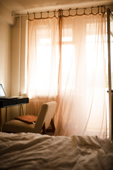 Cozy home interior with bed and working place in sun light. Warm hygge atmosphere.