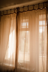 Background of transparent curtains with sun light in room close up. Good morning. Selective focus.