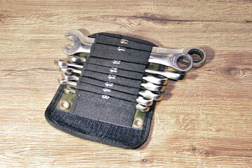 A set of wrenches are lined up in a black pouch