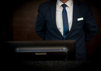 Hotel receptionist standing infront of computer