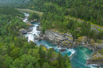 Drone view, aerial view of Romsdalen valley, wild and beautiful valley in western Norway. Wild river with rapids, big rocks, forest and meadows on riverbanks. Impressive nature. Norwegian wilderness, 